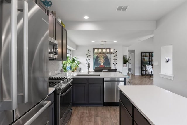 141 Witchhazel Way, San Marcos, TX 78666 - kitchen featuring stainless steel appliances, a peninsula, light countertops, recessed lighting, and wood finished floors