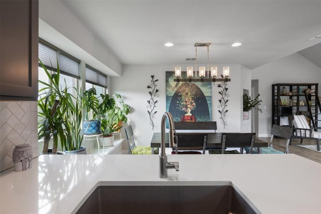 141 Witchhazel Way, San Marcos, TX 78666 - kitchen with light countertops, hanging light fixtures, recessed lighting, backsplash, and dark brown cabinets