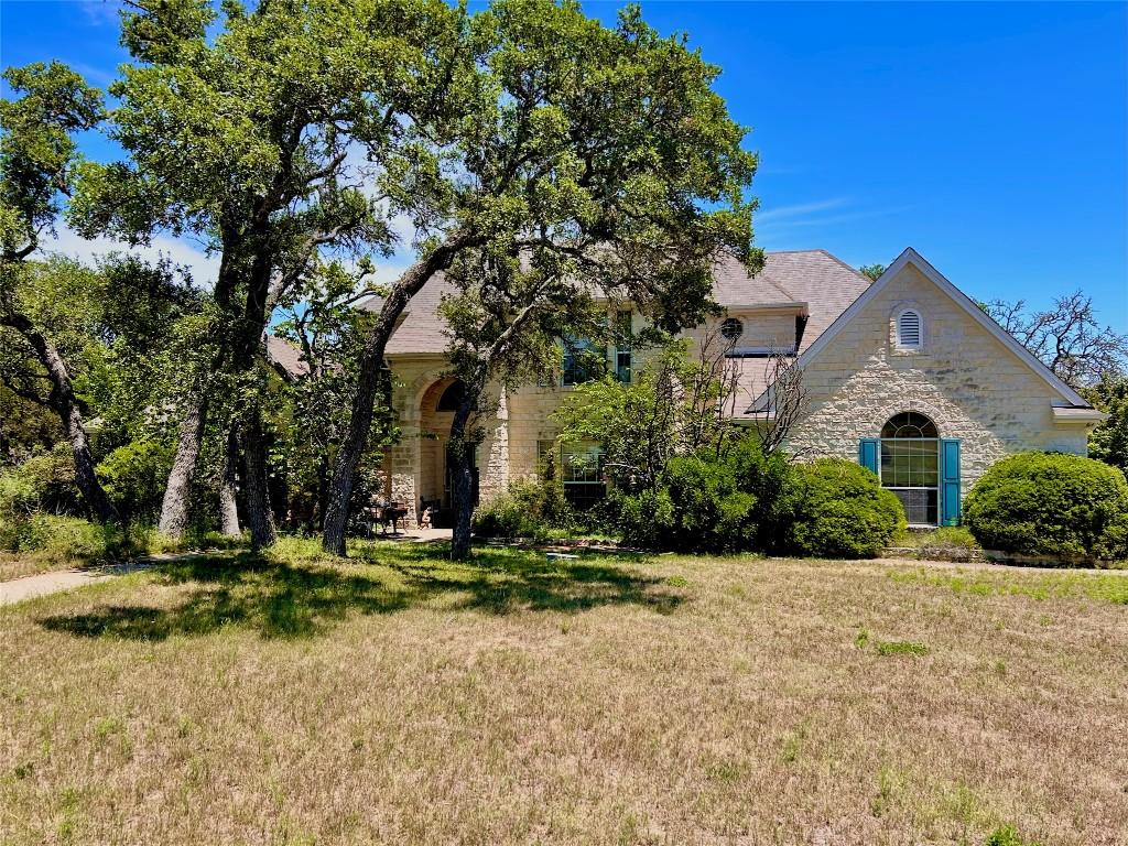 view of front of home featuring stone siding and a front lawn