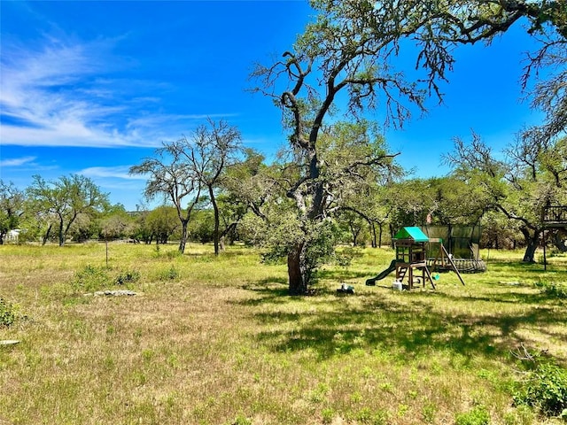view of green lawn featuring a playground