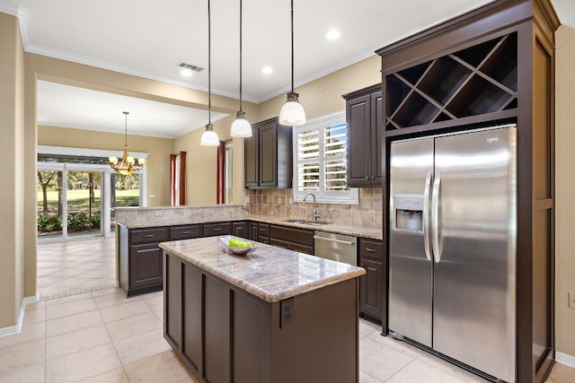 214 Lone Star Dr, Georgetown, TX 78633 - kitchen with stainless steel appliances, plenty of natural light, backsplash, a chandelier, and ornamental molding