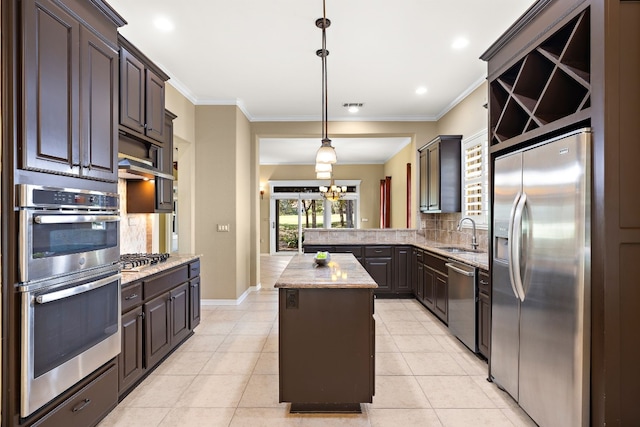 214 Lone Star Dr, Georgetown, TX 78633 - kitchen with appliances with stainless steel finishes, a sink, a center island, tasteful backsplash, and crown molding