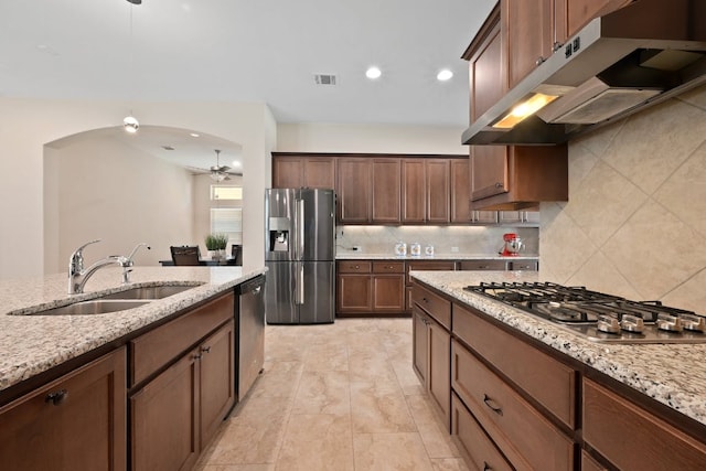 6321 Llano Stage Trl, Austin, TX 78738 - kitchen with appliances with stainless steel finishes, under cabinet range hood, a sink, a ceiling fan, and tasteful backsplash