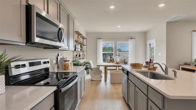 100 Heatherwood Ter, Marble Falls, TX 78654 - kitchen with appliances with stainless steel finishes, a sink, gray cabinetry, light wood-type flooring, and recessed lighting