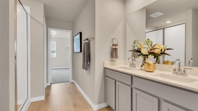 100 Heatherwood Ter, Marble Falls, TX 78654 - bathroom featuring wood finished floors, double vanity, a stall shower, and baseboards