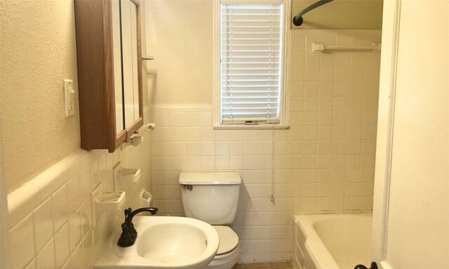 301 E 34th St Unit 107, Austin, TX 78705 - full bath with tile walls, a sink, toilet, and wainscoting