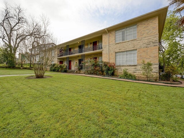 301 E 34th St Unit 107, Austin, TX 78705 - view of front of home featuring a front yard, a balcony, and brick siding
