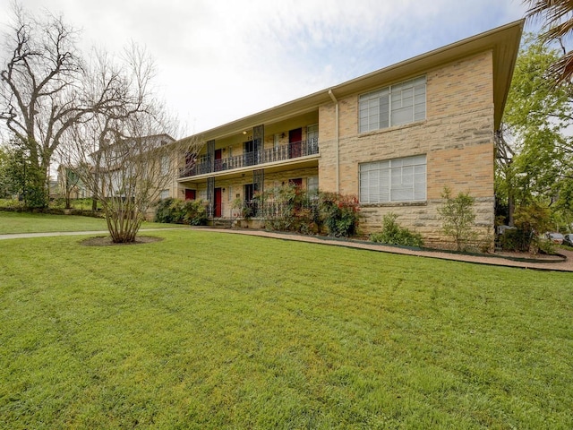 301 E 34th St Unit 107, Austin, TX 78705 - view of front of home featuring a front lawn, a balcony, and brick siding