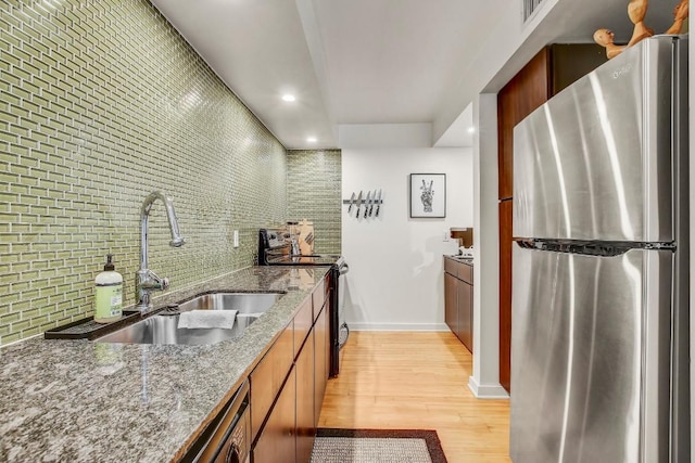 2200 Dickson Dr Unit 132, Austin, TX 78704 - kitchen featuring stainless steel appliances, a sink, light wood-style floors, tasteful backsplash, and recessed lighting