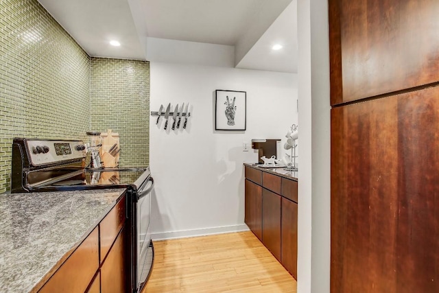 2200 Dickson Dr Unit 132, Austin, TX 78704 - kitchen with stainless steel range with electric cooktop, light wood-style floors, baseboards, recessed lighting, and light stone countertops