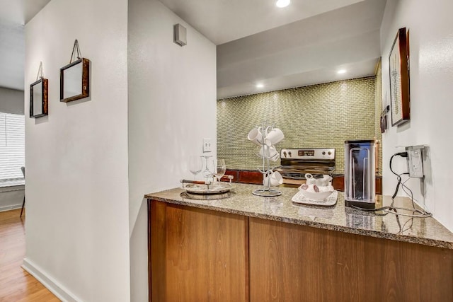 2200 Dickson Dr Unit 132, Austin, TX 78704 - bar with stainless steel electric stove, decorative backsplash, wood finished floors, and baseboards