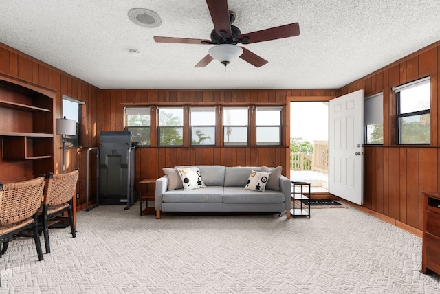 8016 Lupe Ln, Jonestown, TX 78645 - living area with wood walls, a textured ceiling, ceiling fan, and light carpet