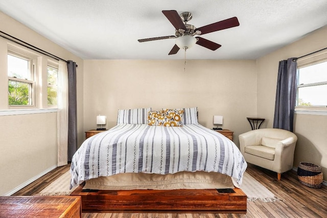 8016 Lupe Ln, Jonestown, TX 78645 - bedroom with multiple windows, wood finished floors, baseboards, and a ceiling fan