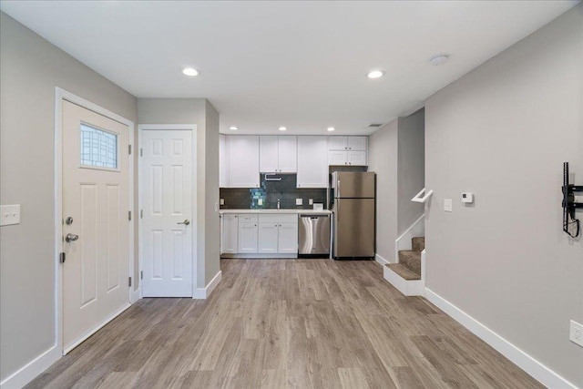 935 La Posada Dr Unit 158, Austin, TX 78752 - kitchen featuring stainless steel appliances, white cabinets, baseboards, light wood-style floors, and recessed lighting