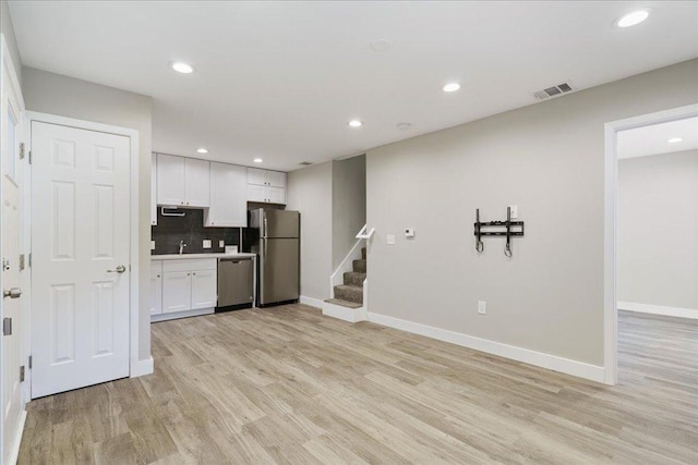 935 La Posada Dr Unit 158, Austin, TX 78752 - kitchen featuring stainless steel appliances, white cabinetry, light wood-style flooring, and recessed lighting