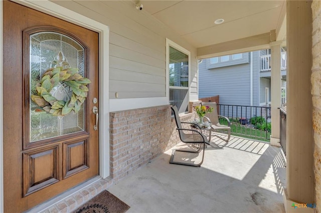 doorway to property featuring a porch and a surveillance system