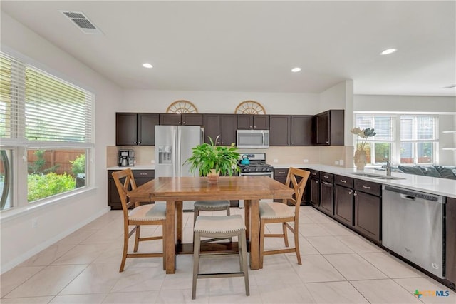 kitchen featuring stainless steel appliances, a sink, healthy amount of natural light, decorative backsplash, and recessed lighting