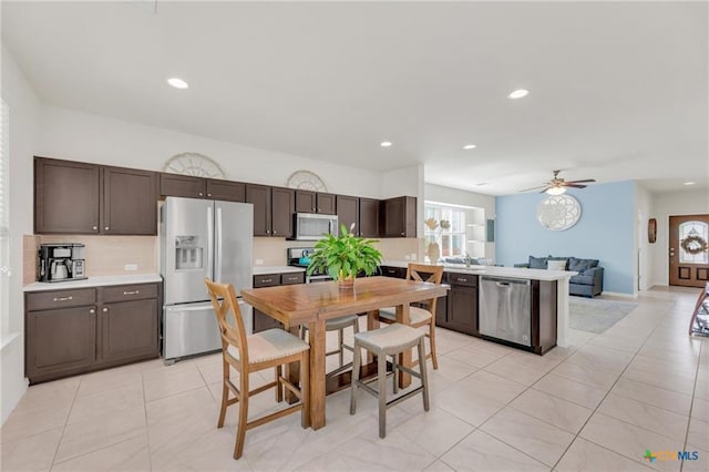 512 Canadian Springs Dr, Leander, TX 78641 - kitchen with stainless steel appliances, dark brown cabinetry, light tile patterned flooring, light countertops, and recessed lighting