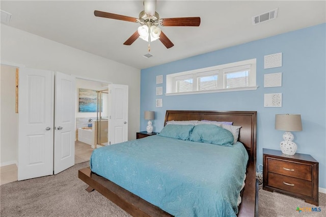 carpeted bedroom with a ceiling fan, ensuite bath, and baseboards