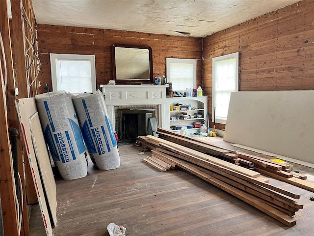 1118 N 2nd St, Temple, TX 76501 - living room featuring hardwood / wood-style floors, wooden walls, and a brick fireplace