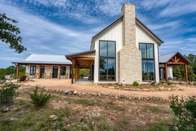 1433 Althaus Ranch Rd, Johnson City, TX 78636 - back of property featuring a standing seam roof, board and batten siding, a chimney, and metal roof