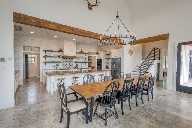 1433 Althaus Ranch Rd, Johnson City, TX 78636 - dining room featuring a high ceiling, plenty of natural light, stairs, a chandelier, and baseboards