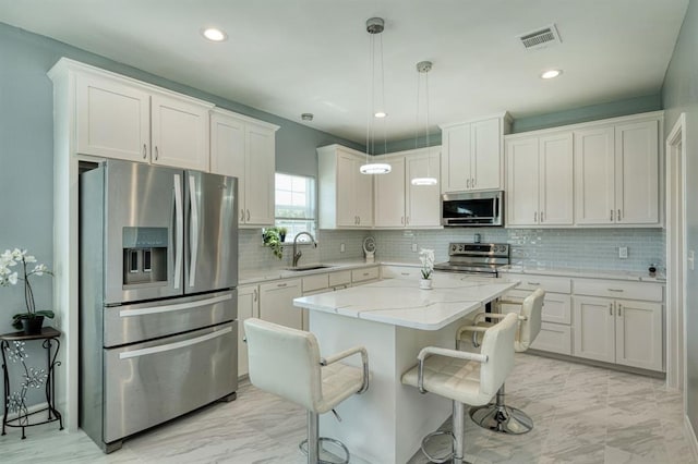 2409 Pecan St, Bastrop, TX 78602 - kitchen featuring appliances with stainless steel finishes, a sink, light marble finish flooring, white cabinets, and recessed lighting