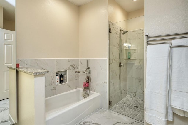 2409 Pecan St, Bastrop, TX 78602 - full bathroom featuring marble finish flooring, a shower stall, a bath, and a wainscoted wall