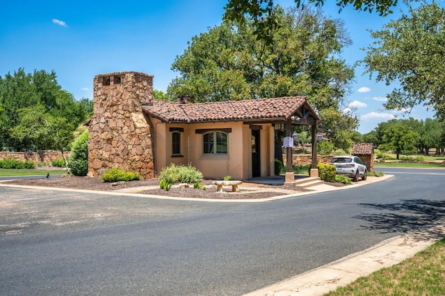 305 Indigo Ln, Georgetown, TX 78628 - view of front of house with a tile roof, stucco siding, and a chimney