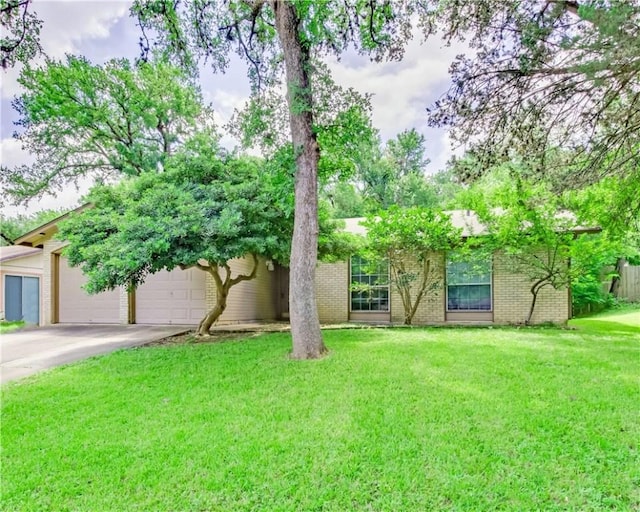 7309 Whispering Oaks Dr, Austin, TX 78745 - view of front facade with concrete driveway, a front lawn, brick siding, and an attached garage