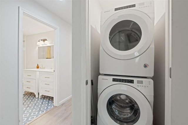306 Juarez St, San Marcos, TX 78666 - washroom with stacked washing machine and dryer and light wood-style flooring