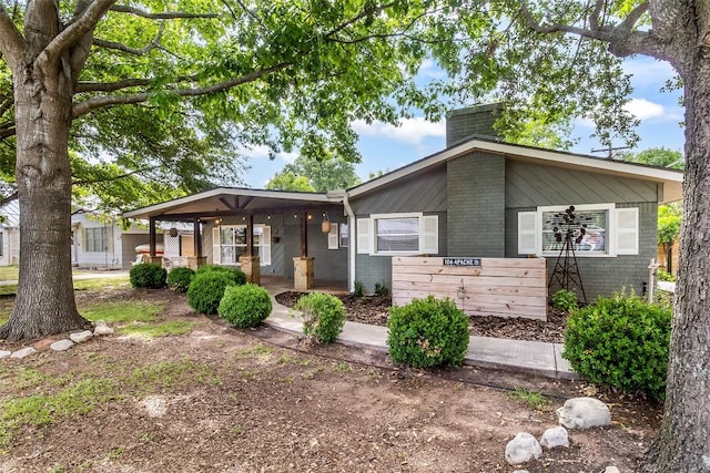 106 Apache Trl, Kingsland, TX 78639 - view of front of property featuring a chimney, covered porch, and brick siding