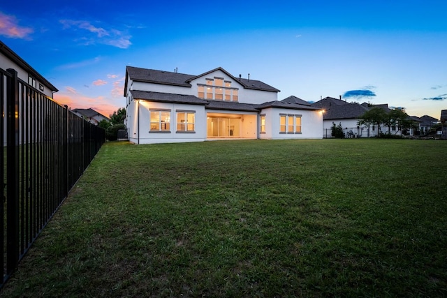 1928 Portobello Rd, Leander, TX 78641 - back of house at dusk featuring a fenced backyard and stucco siding