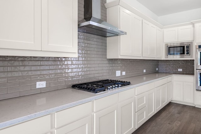 1928 Portobello Rd, Leander, TX 78641 - kitchen featuring wall chimney range hood, appliances with stainless steel finishes, dark wood-style flooring, and white cabinetry