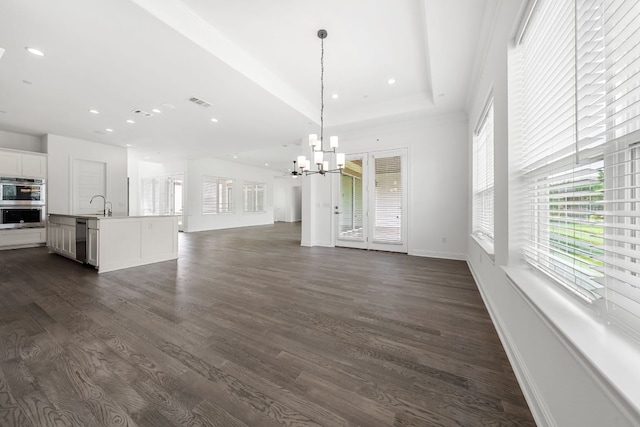 1928 Portobello Rd, Leander, TX 78641 - unfurnished living room featuring a chandelier, dark wood-style flooring, recessed lighting, and a raised ceiling