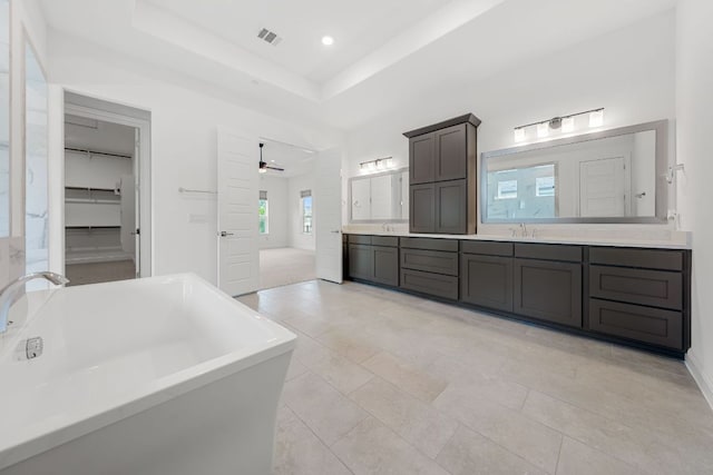 1928 Portobello Rd, Leander, TX 78641 - full bathroom with double vanity, a freestanding tub, recessed lighting, a tray ceiling, and ceiling fan