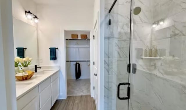 2593 Jack Nora Way, Round Rock, TX 78665 - full bath featuring a marble finish shower, wood finished floors, double vanity, and a spacious closet