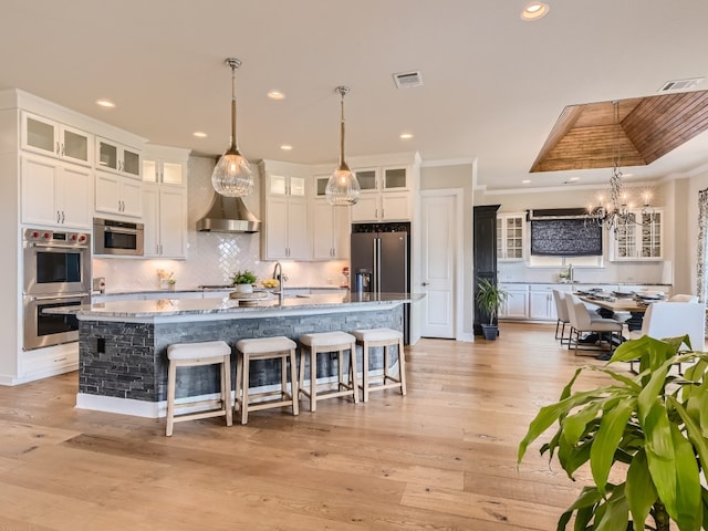 240 Townes Ct, Dripping Springs, TX 78620 - kitchen with stainless steel appliances, white cabinetry, a sink, tasteful backsplash, and a kitchen bar
