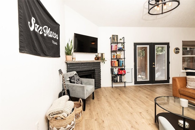 311 Quarry St, San Marcos, TX 78666 - living room with wood finished floors, a chandelier, a fireplace, and french doors