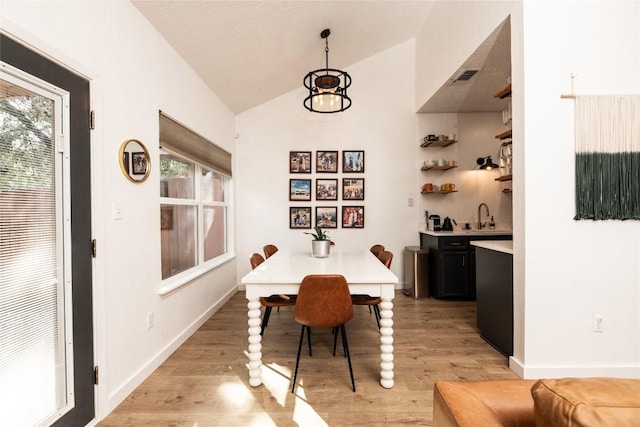 311 Quarry St, San Marcos, TX 78666 - dining room featuring lofted ceiling, light wood finished floors, and baseboards