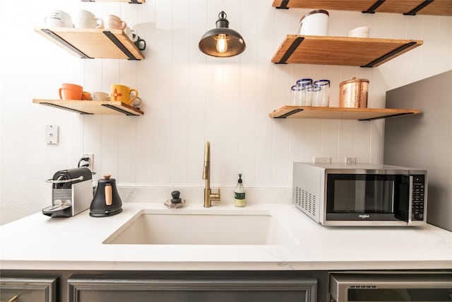 311 Quarry St, San Marcos, TX 78666 - kitchen featuring stainless steel microwave, a sink, dishwashing machine, and open shelves
