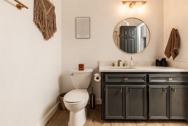 311 Quarry St, San Marcos, TX 78666 - bathroom featuring vanity, wood finished floors, baseboards, and toilet