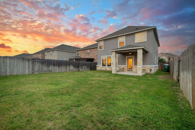 209 Sage Derby Dr, Hutto, TX 78634 - back of property at dusk featuring stone siding, stucco siding, and a patio