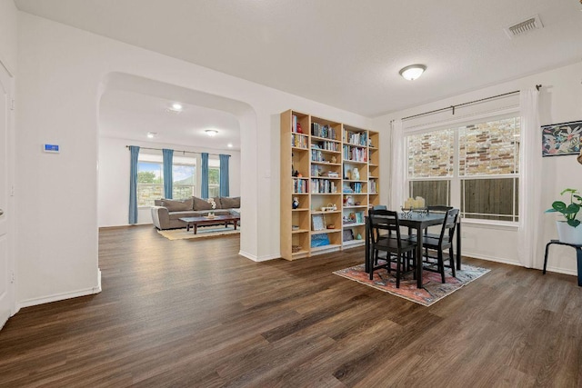 209 Sage Derby Dr, Hutto, TX 78634 - dining room with dark wood-type flooring, arched walkways, and baseboards