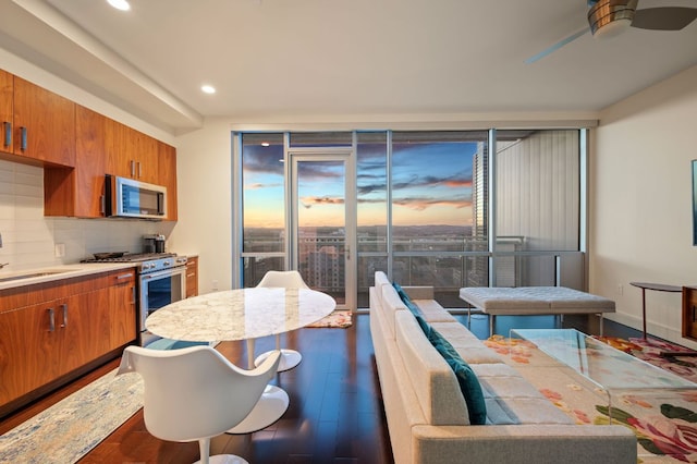 222 W Ave Unit 1908, Austin, TX 78701 - kitchen featuring stainless steel appliances, floor to ceiling windows, brown cabinets, a sink, and ceiling fan