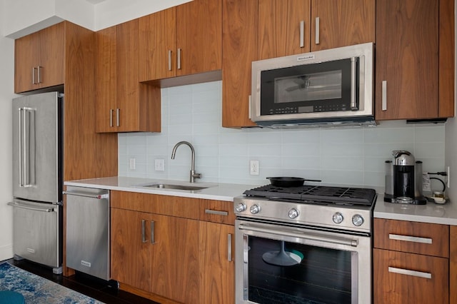 222 W Ave Unit 1908, Austin, TX 78701 - kitchen with appliances with stainless steel finishes, a sink, light countertops, brown cabinets, and backsplash