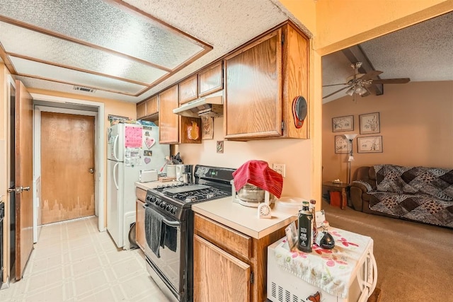 1906 Dry Creek Dr, Round Rock, TX 78681 - kitchen with range with gas cooktop, under cabinet range hood, a ceiling fan, freestanding refrigerator, and a textured ceiling