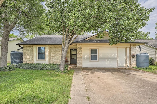 1906 Dry Creek Dr, Round Rock, TX 78681 - view of front of home with stone siding, driveway, a shingled roof, and a front yard
