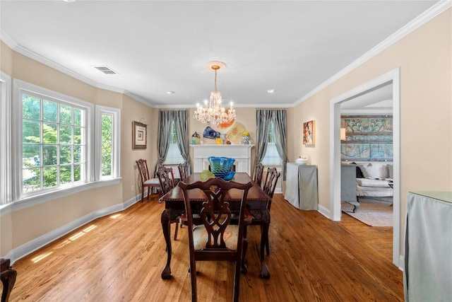 1704 W 34th St, Austin, TX 78703 - dining room with a chandelier, baseboards, light wood-type flooring, and crown molding