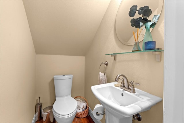 1704 W 34th St, Austin, TX 78703 - half bathroom with wood finished floors, toilet, lofted ceiling, and a sink
